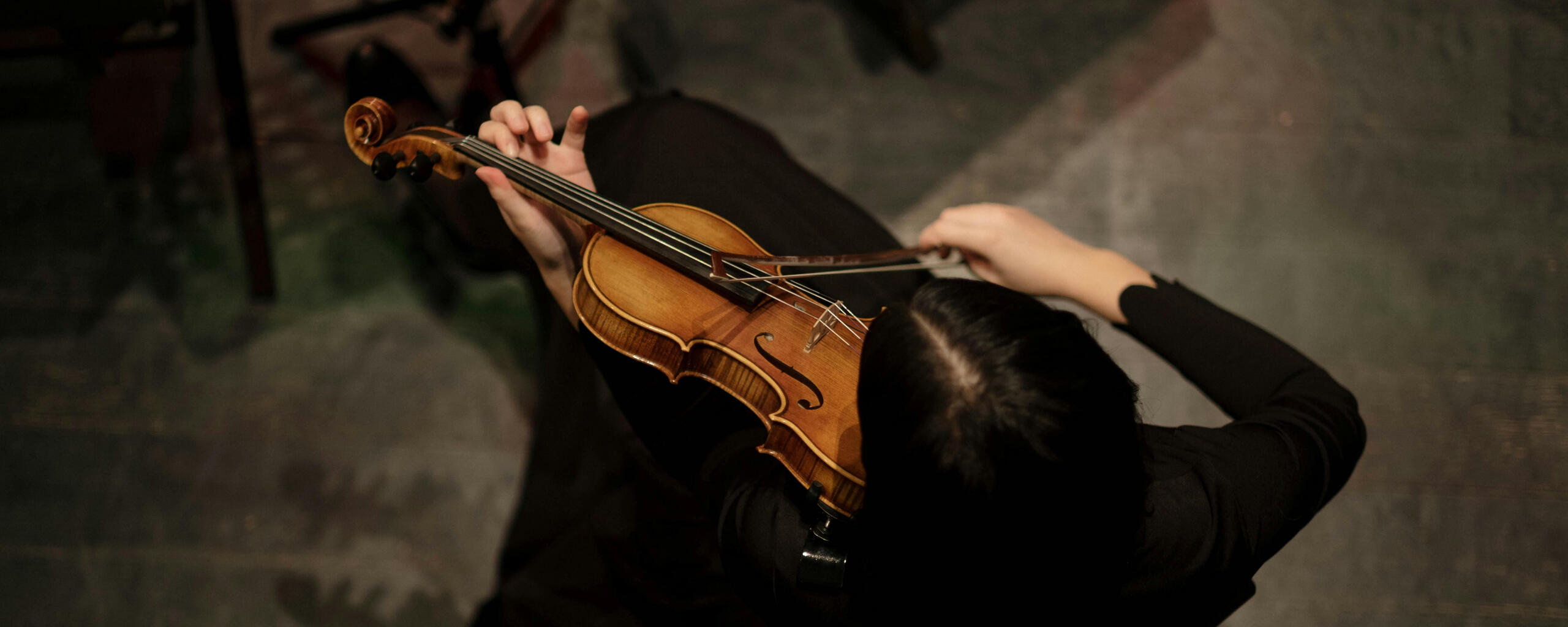 Aerial top-down view of a person playing the violin.